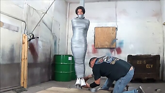 Voluptuous Woman Restrained To A Pole With Duct Tape For Bondage Play